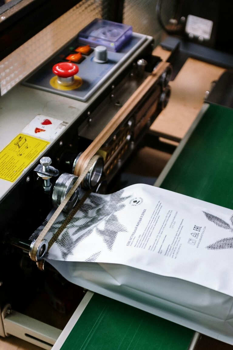 Close-up of a coffee bag being sealed by an industrial machine, showcasing manufacturing precision.