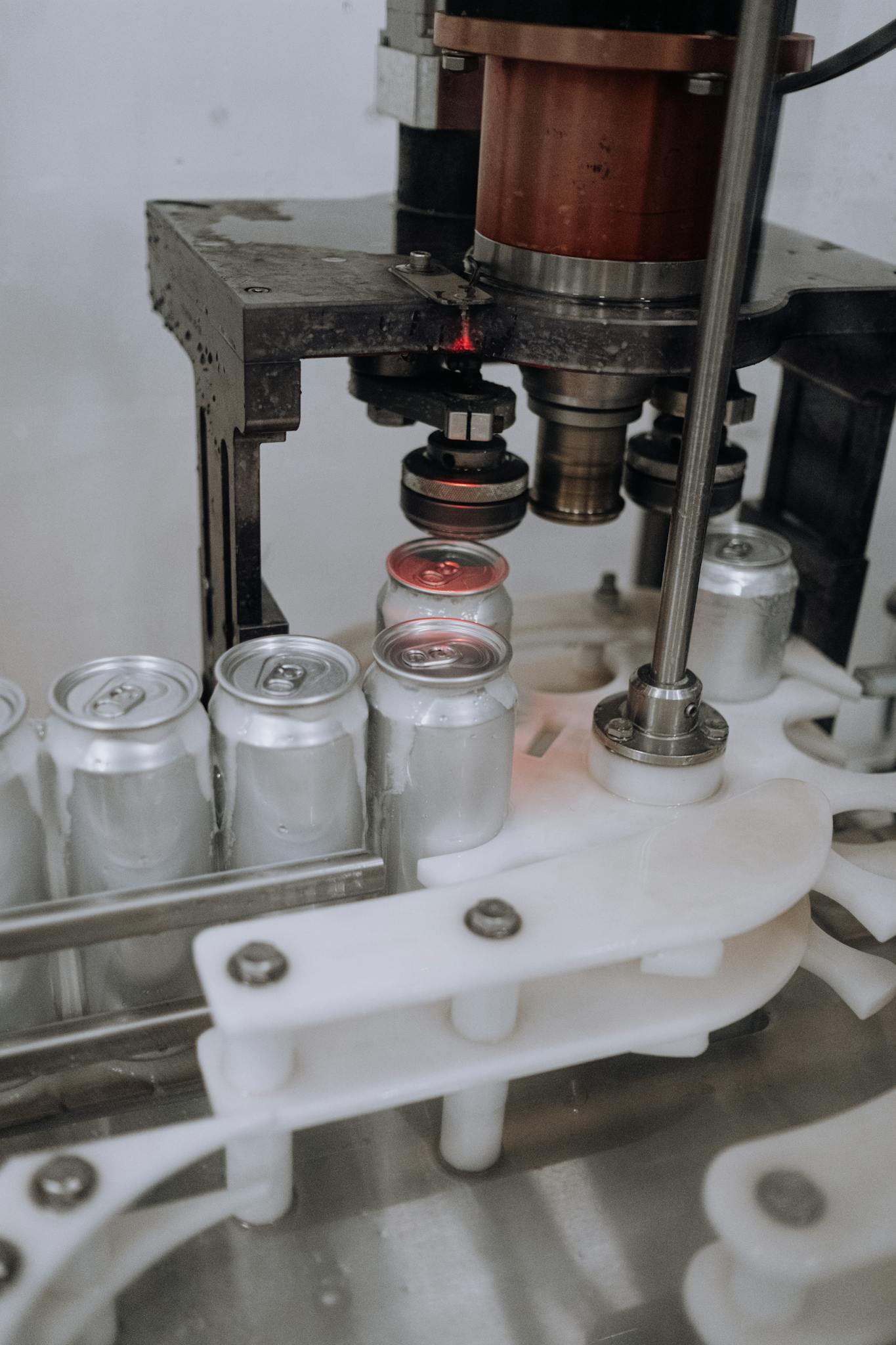 Close-up of beverage cans on an automated assembly line in a factory.