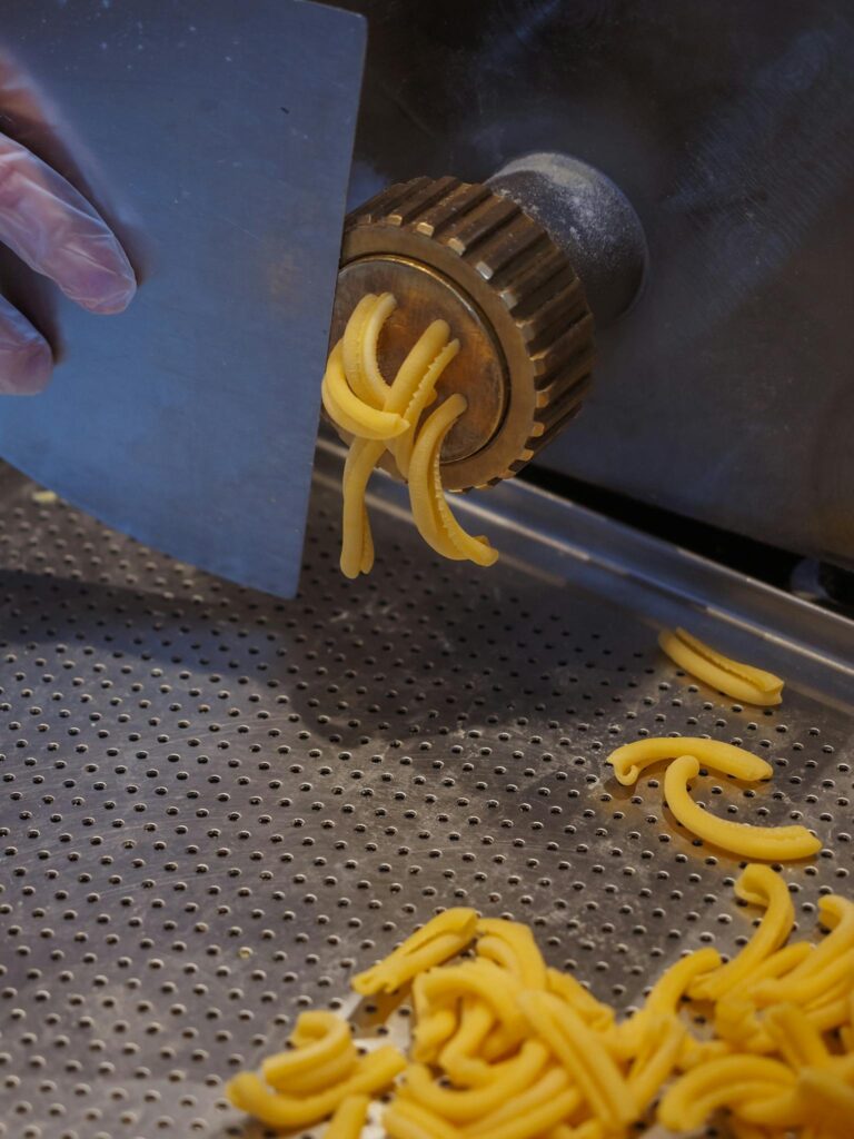 Fresh pasta being produced by an industrial machine, highlighting the food production process.